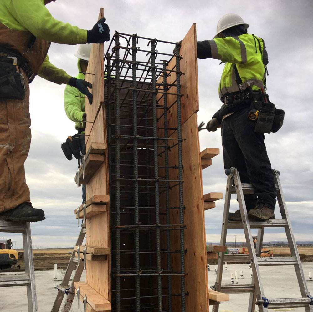 Construction workers assembling rebar pillars